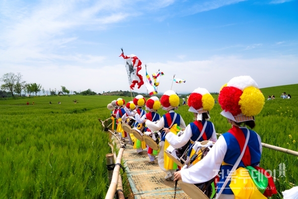 고창 청보리밭을 찾은 관광객들에게 길놀이로 즐거움을 주고 있다.